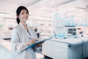 3交代／ラインから流れてくる点滴バッグに手作業で取り付ける作業
