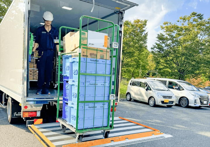 トラックから荷物を下ろす社員