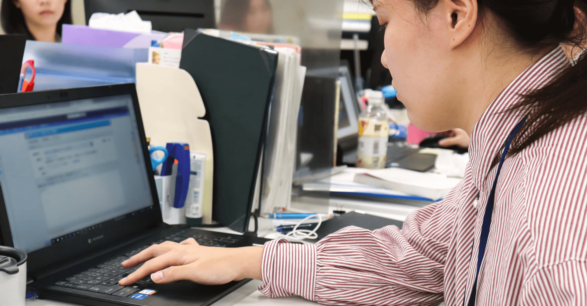 上下肢障がいの女性従業員はパソコンを使って仕事をしている